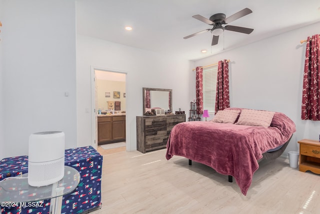 bedroom with ensuite bath, light wood-type flooring, and ceiling fan