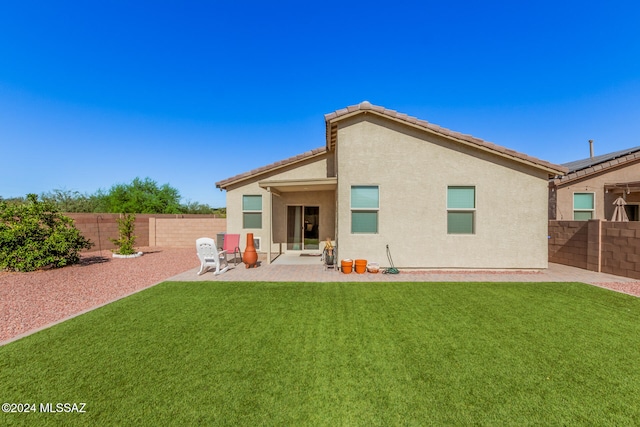 rear view of house with a patio and a lawn