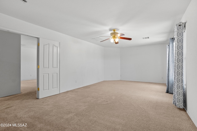 empty room with ceiling fan and light colored carpet