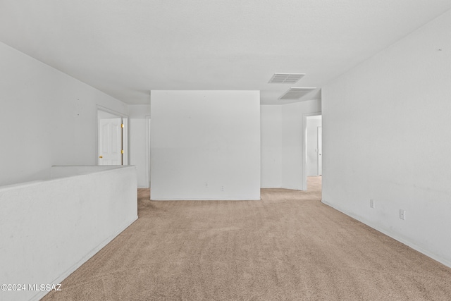 spare room featuring light carpet