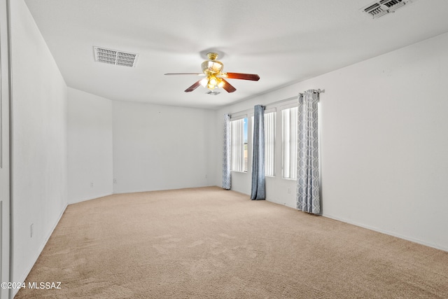 carpeted spare room featuring ceiling fan