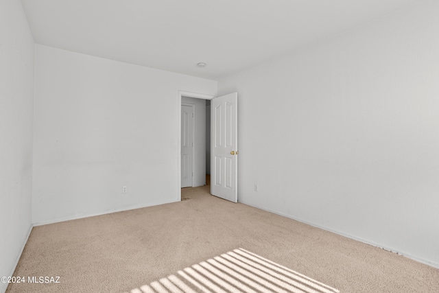 spare room featuring light colored carpet