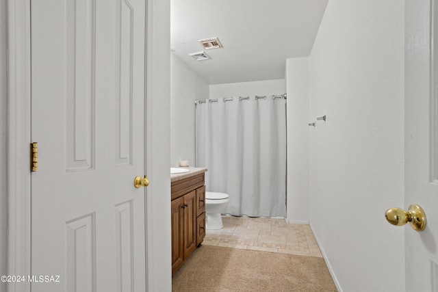 bathroom featuring vanity, curtained shower, and toilet