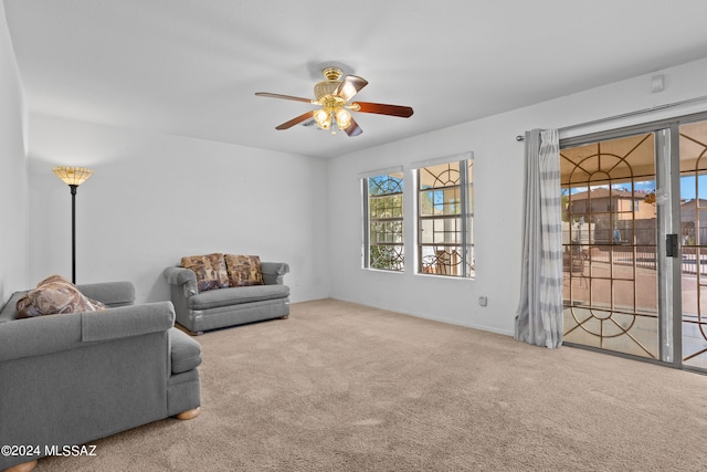 carpeted living room featuring ceiling fan