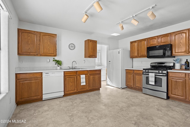 kitchen featuring sink, track lighting, and white appliances