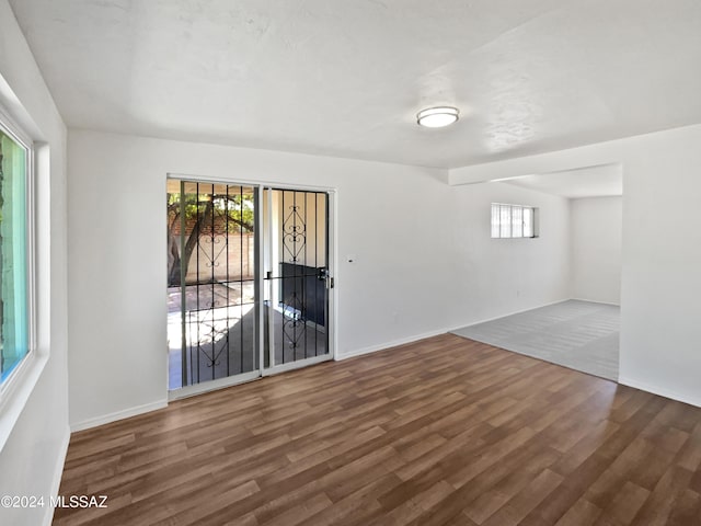 unfurnished room with a wealth of natural light and hardwood / wood-style flooring