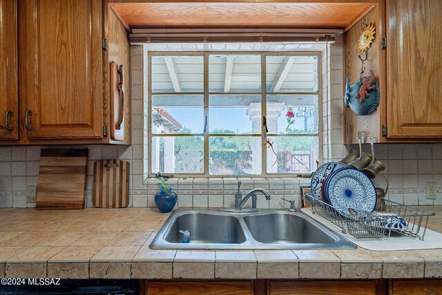 kitchen with tile countertops, decorative backsplash, kitchen peninsula, and stainless steel appliances