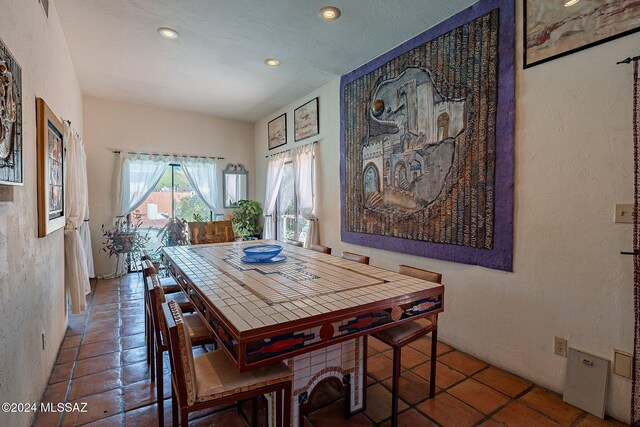 dining space with dark tile patterned floors