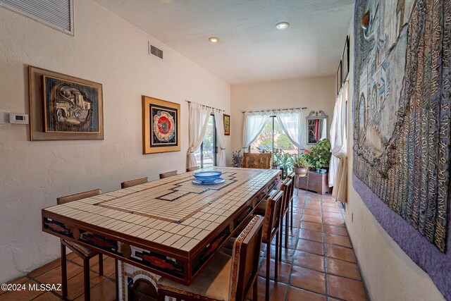 dining area featuring dark tile patterned flooring