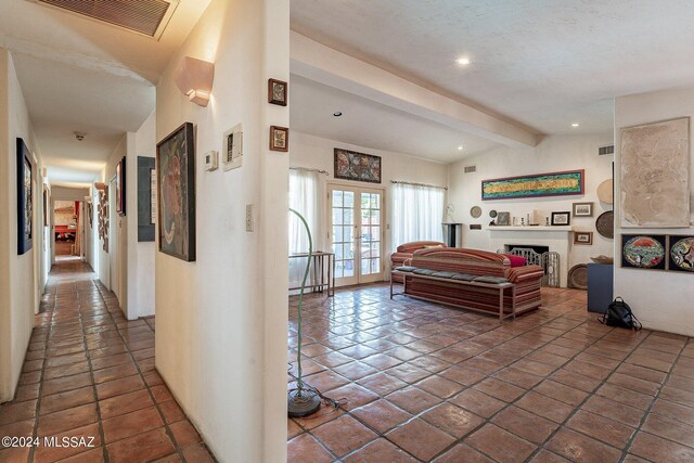 living room with lofted ceiling with beams and tile patterned floors