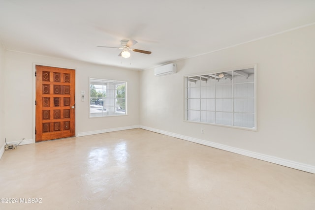 spare room with an AC wall unit and ceiling fan