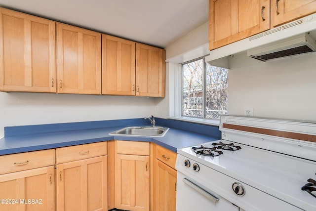 kitchen with light brown cabinets, white stove, and sink