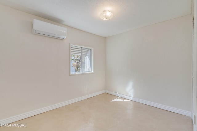 unfurnished room with a wall mounted AC and a textured ceiling