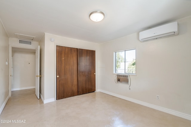 unfurnished bedroom featuring cooling unit, a closet, and an AC wall unit