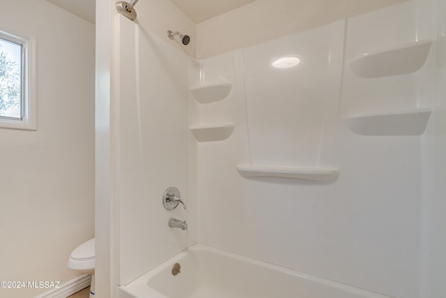 bathroom with bathing tub / shower combination and toilet