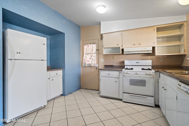 kitchen featuring white appliances, tasteful backsplash, sink, light tile patterned flooring, and white cabinetry