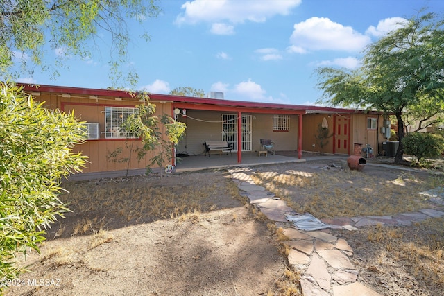 rear view of house with central AC and a patio