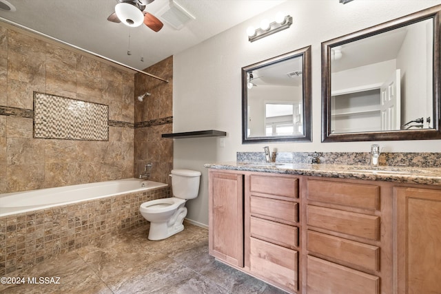 full bathroom with toilet, tiled shower / bath, vanity, and ceiling fan