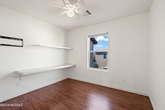 unfurnished room featuring dark wood-type flooring and ceiling fan