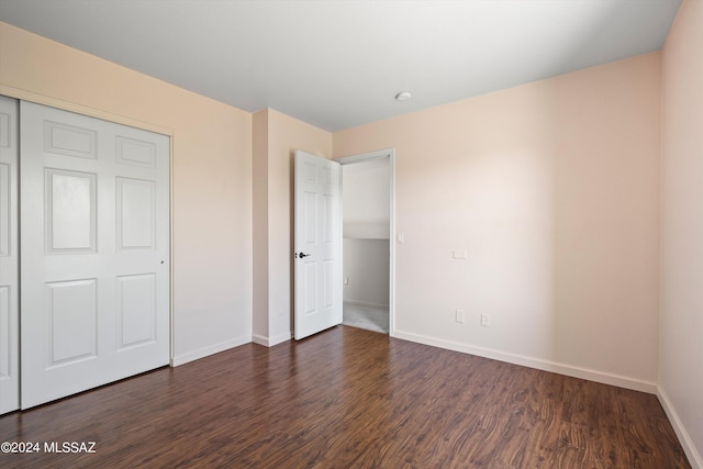 unfurnished bedroom featuring dark hardwood / wood-style floors and a closet