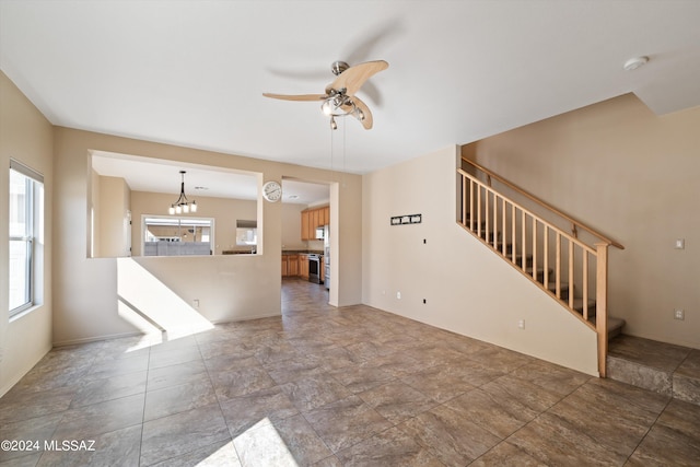 unfurnished living room with ceiling fan with notable chandelier