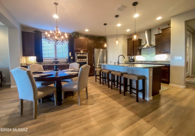 dining room featuring light hardwood / wood-style floors, a notable chandelier, and sink