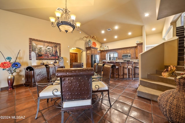 tiled dining room featuring high vaulted ceiling and an inviting chandelier