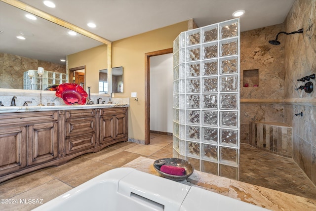 bathroom featuring a tile shower and vanity