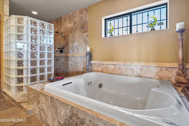 bathroom with a relaxing tiled tub