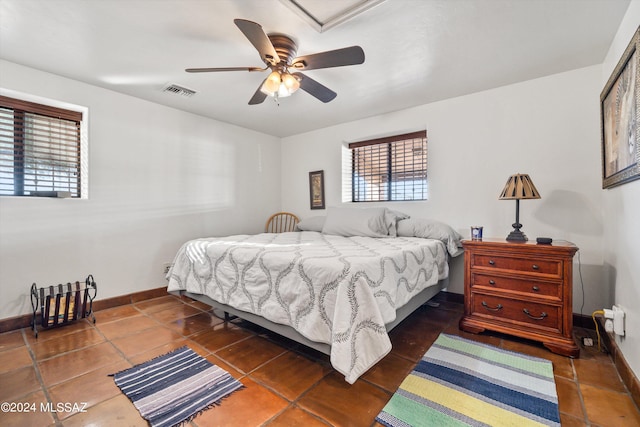 bedroom featuring dark tile patterned flooring, multiple windows, and ceiling fan