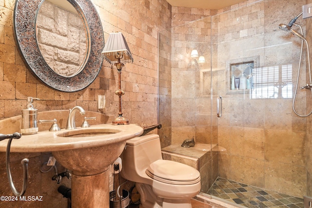 bathroom featuring a shower with door, toilet, and tile walls