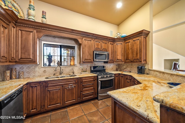 kitchen featuring tasteful backsplash, stainless steel appliances, sink, and light stone counters