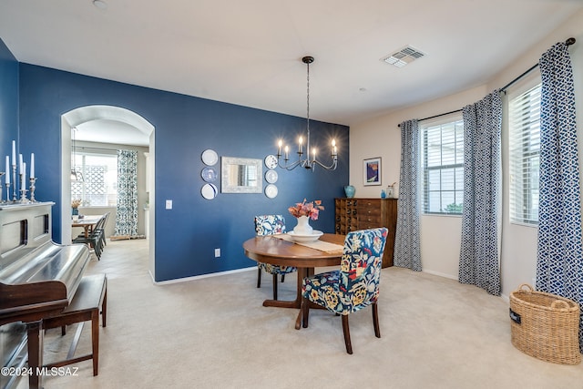 dining room featuring light carpet and an inviting chandelier