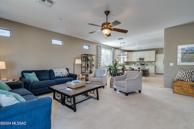 carpeted living room with ceiling fan