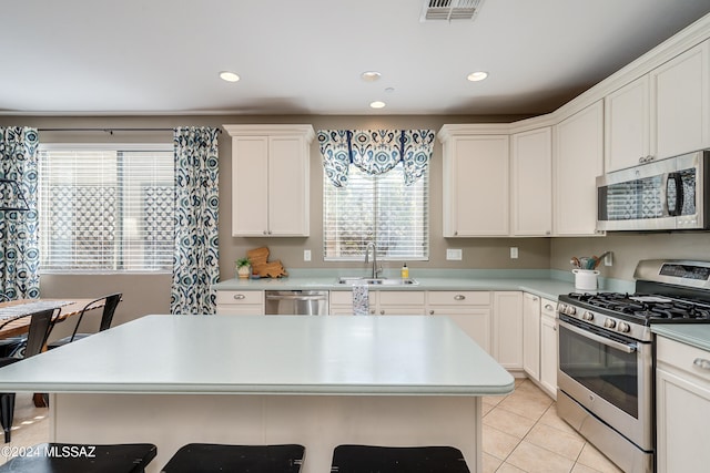 kitchen with white cabinetry, light tile patterned flooring, appliances with stainless steel finishes, and sink