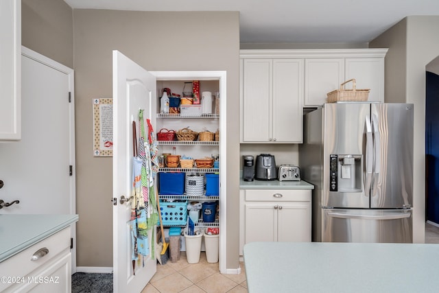 kitchen with white cabinetry, light tile patterned floors, and stainless steel fridge with ice dispenser