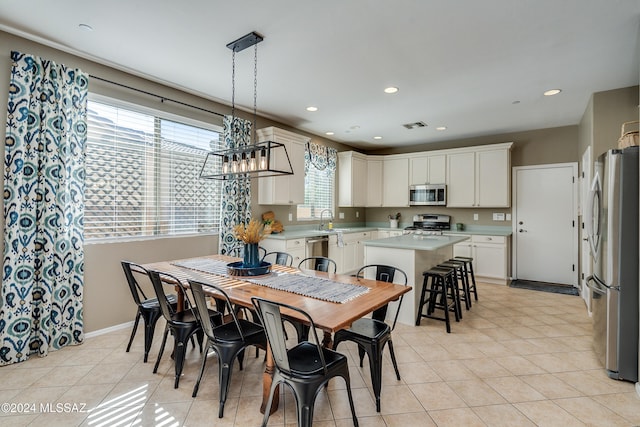 tiled dining space with a chandelier and sink