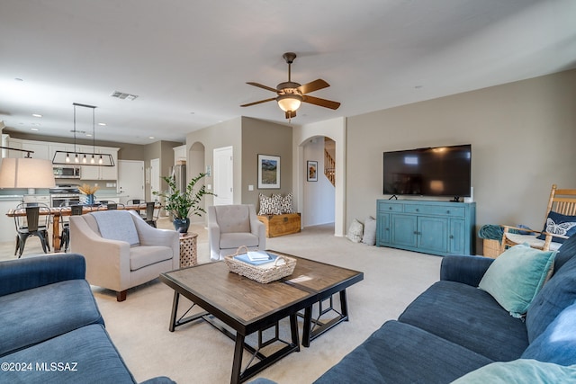 carpeted living room with ceiling fan