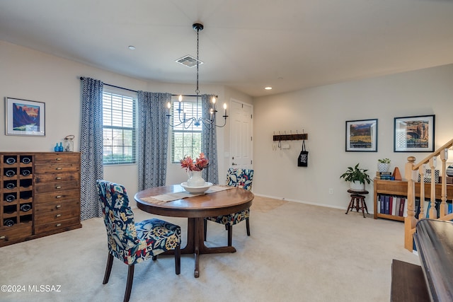 dining room with a chandelier and light colored carpet