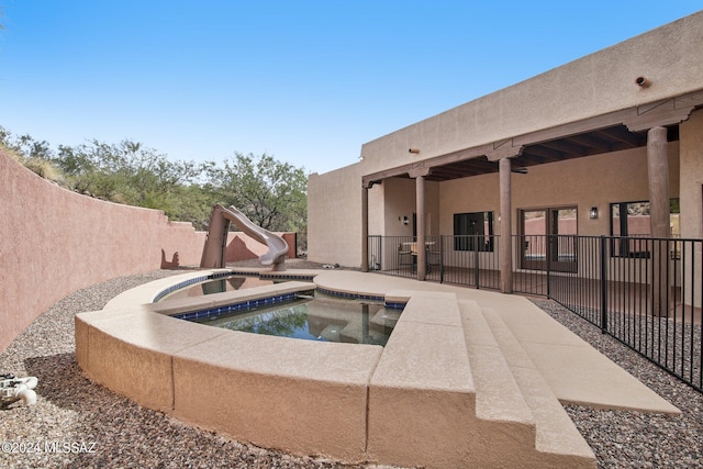 view of swimming pool with a fenced in pool, a patio area, an in ground hot tub, a water slide, and a fenced backyard