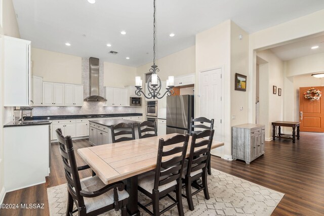 dining area with dark hardwood / wood-style flooring, a chandelier, and sink