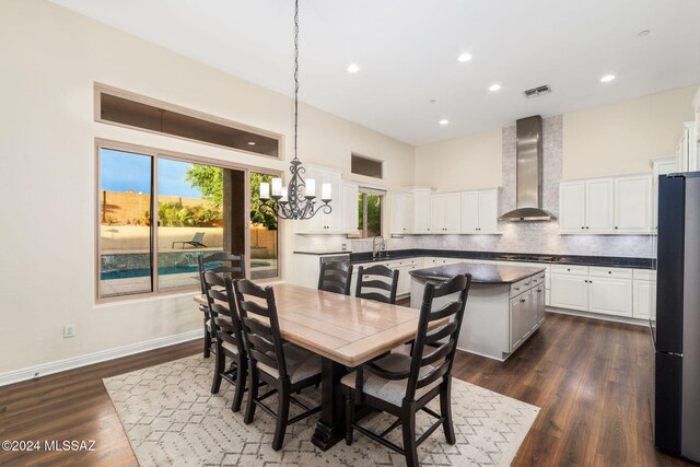 dining room with dark wood-type flooring, a chandelier, and sink