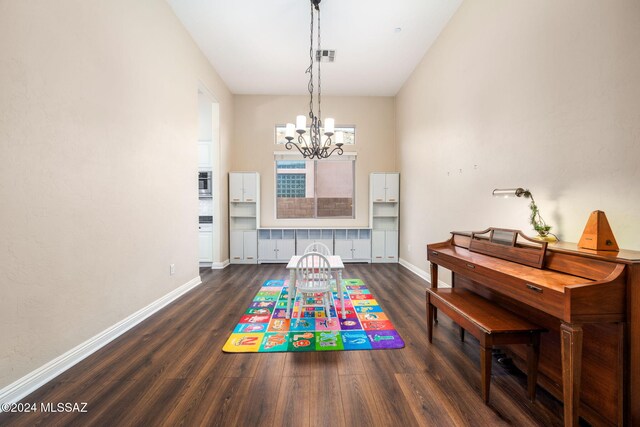 recreation room with a notable chandelier and dark hardwood / wood-style floors