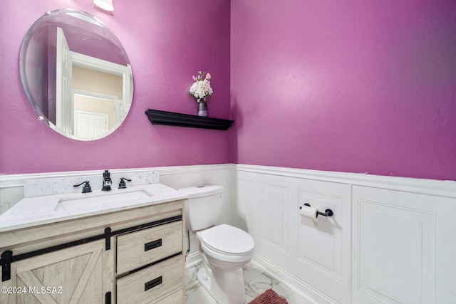 1220 W Calabria Ct, Tucson, AZ 85755 - bathroom featuring marble finish flooring, toilet, a wainscoted wall, and vanity