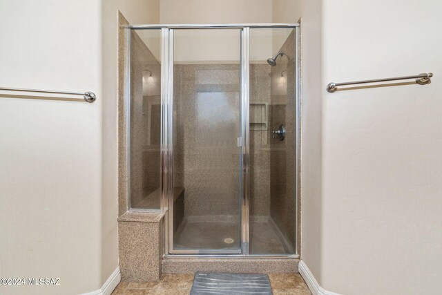 bathroom with a shower with shower door and tile patterned flooring