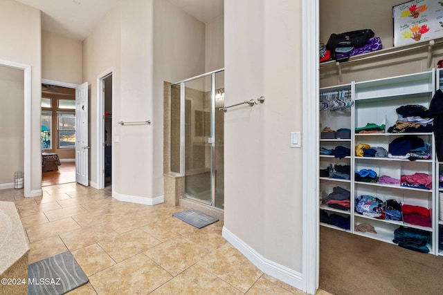 1220 W Calabria Ct, Tucson, AZ 85755 - bathroom featuring a walk in closet, baseboards, and a stall shower