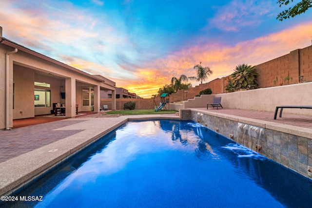 1220 W Calabria Ct, Tucson, AZ 85755 - pool at dusk with a playground, a patio, and a fenced backyard
