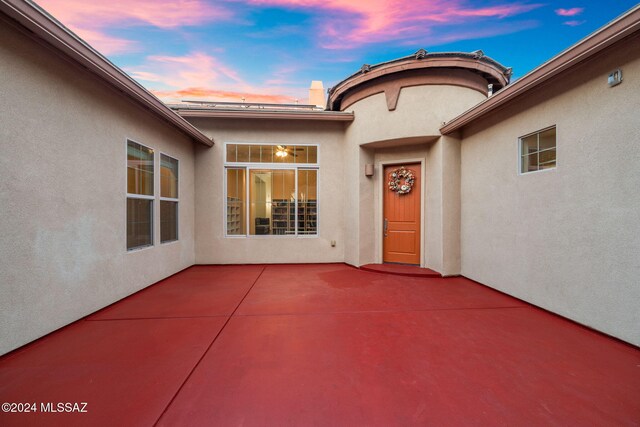 exterior entry at dusk featuring a patio