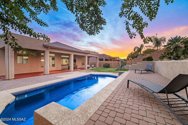 pool at dusk with a patio