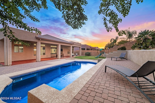 1220 W Calabria Ct, Tucson, AZ 85755 - pool at dusk with a playground, a patio, and a fenced backyard